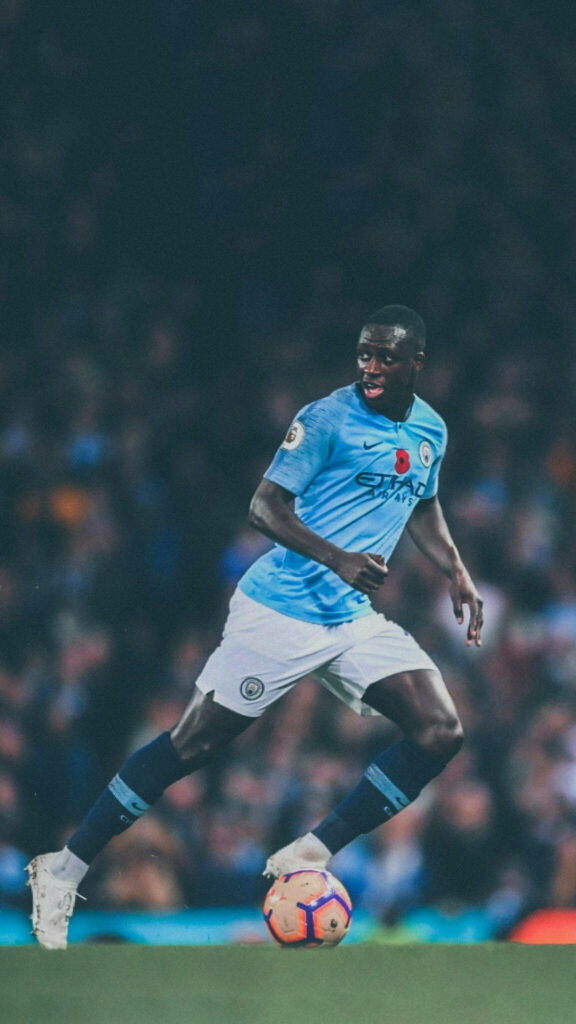 Benjamin Mendy running on football field wearing Manchester City kit during match wallpaper background