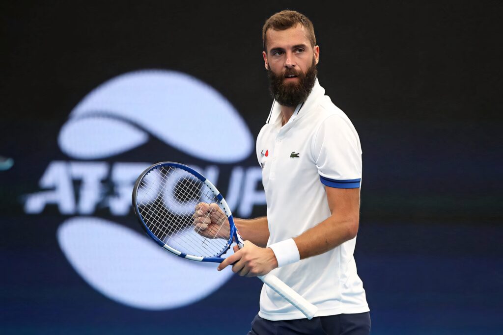 Benoît Paire focused on ATP Cup court holding racquet with vibrant tournament background wallpaper