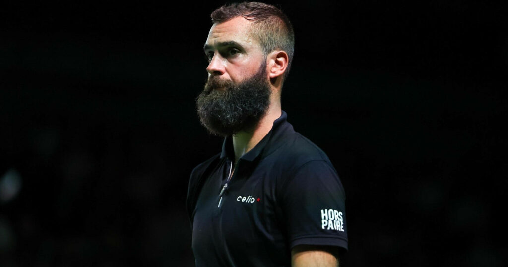 Side profile of Benoit Paire with intense expression and signature beard on black background wallpaper