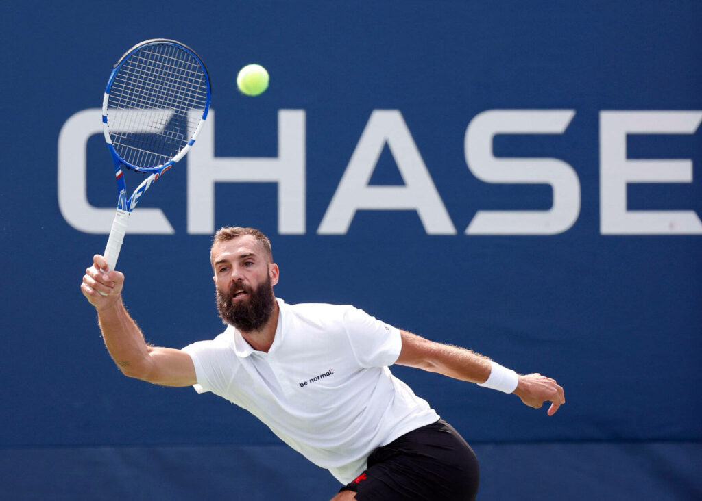 Benoît Paire stretching to return tennis ball on blue court during intense match play wallpaper
