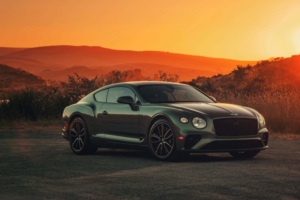 Majestic Bentley Continental GT amidst Breathtaking Scenery, Emphasizing its Flawless Craftsmanship and Dominant Aura Wallpaper