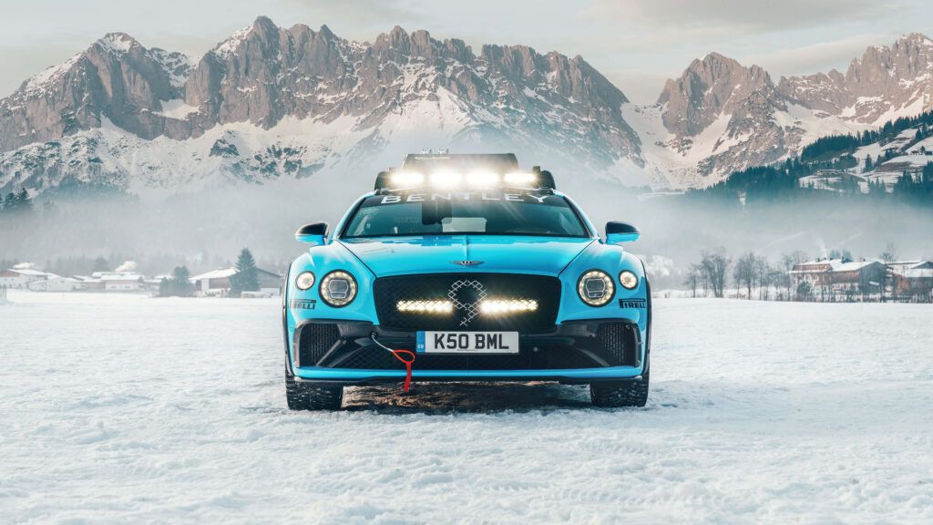 Bentley rally car speeding on snowy terrain with majestic mountains high resolution 8K wallpaper