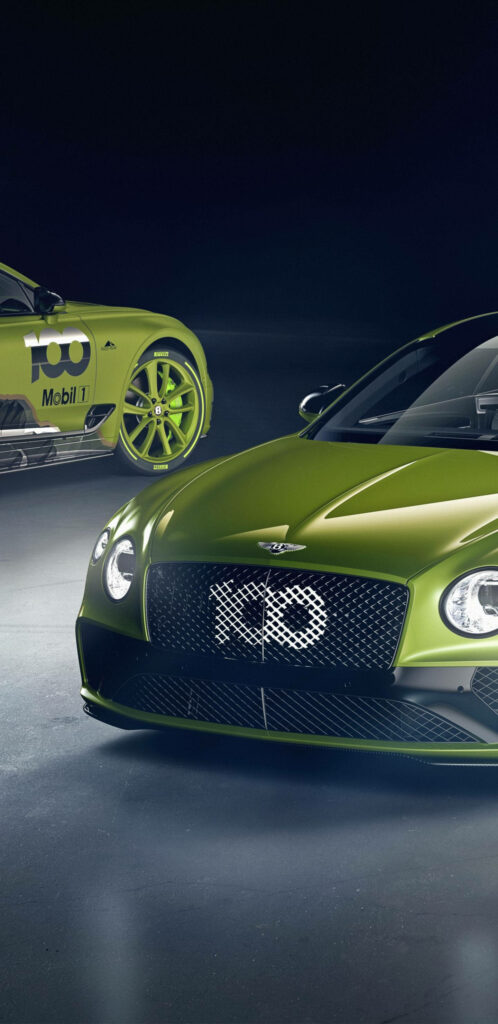 Dual Yellow-Green Bentleys Gracefully Face Off in a Mystical Setting Wallpaper