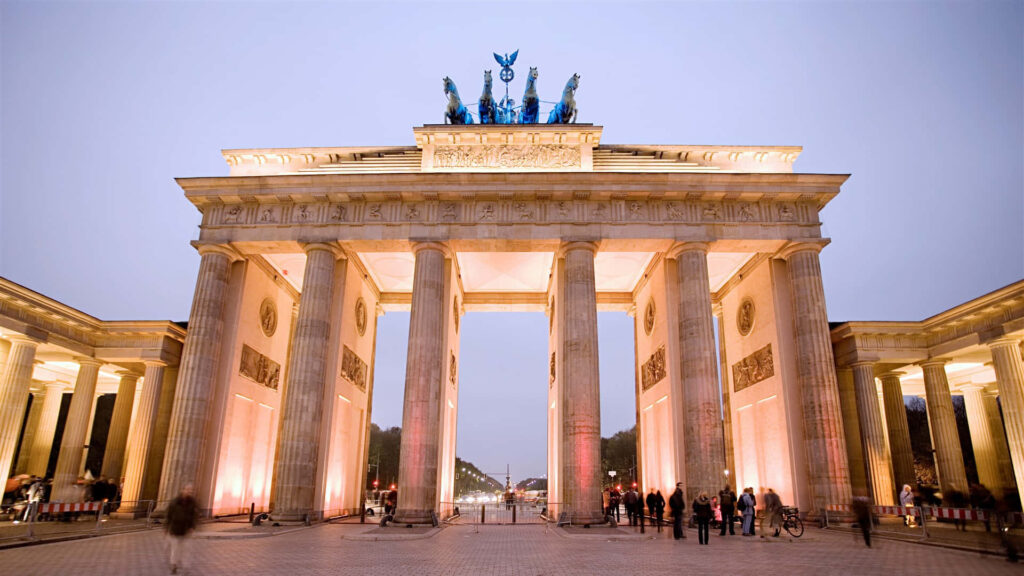 Berlin Brandenburg Gate with Quadriga sculpture illuminated at evening sky neoclassical landmark Wallpaper
