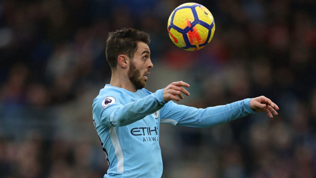 Bernardo Silva heads the ball with sharp focus in intense football match wallpaper background