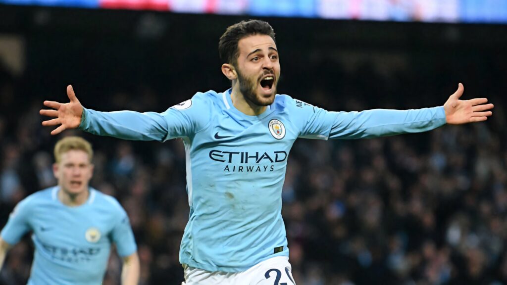 Bernardo Silva raising arms passionately showing determination and intensity in football match Wallpaper