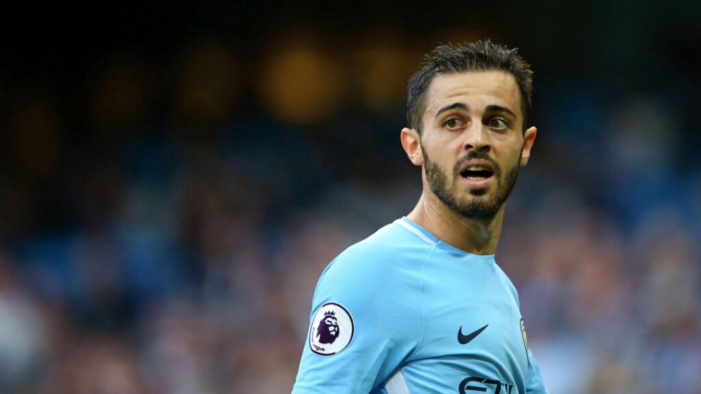 Bernardo Silva in blue Manchester City uniform looking left blurred stadium background wallpaper