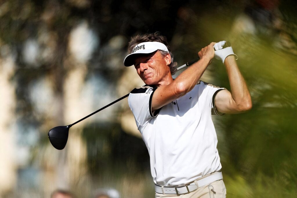 Bernhard Langer mid swing golf course focused expert precision dynamic wallpaper background