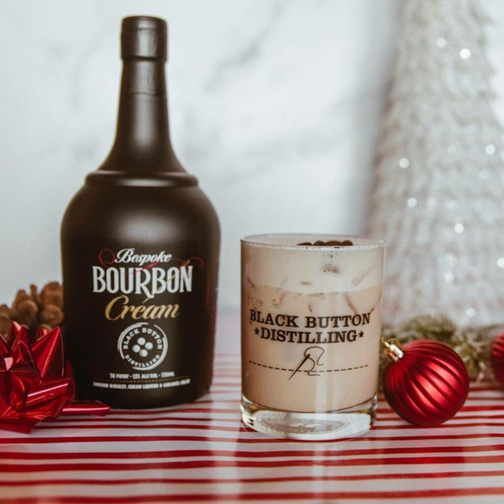 Bespoke Bourbon Cream and creamy cocktail by Black Button Distilling holiday pinecones gift background Wallpaper