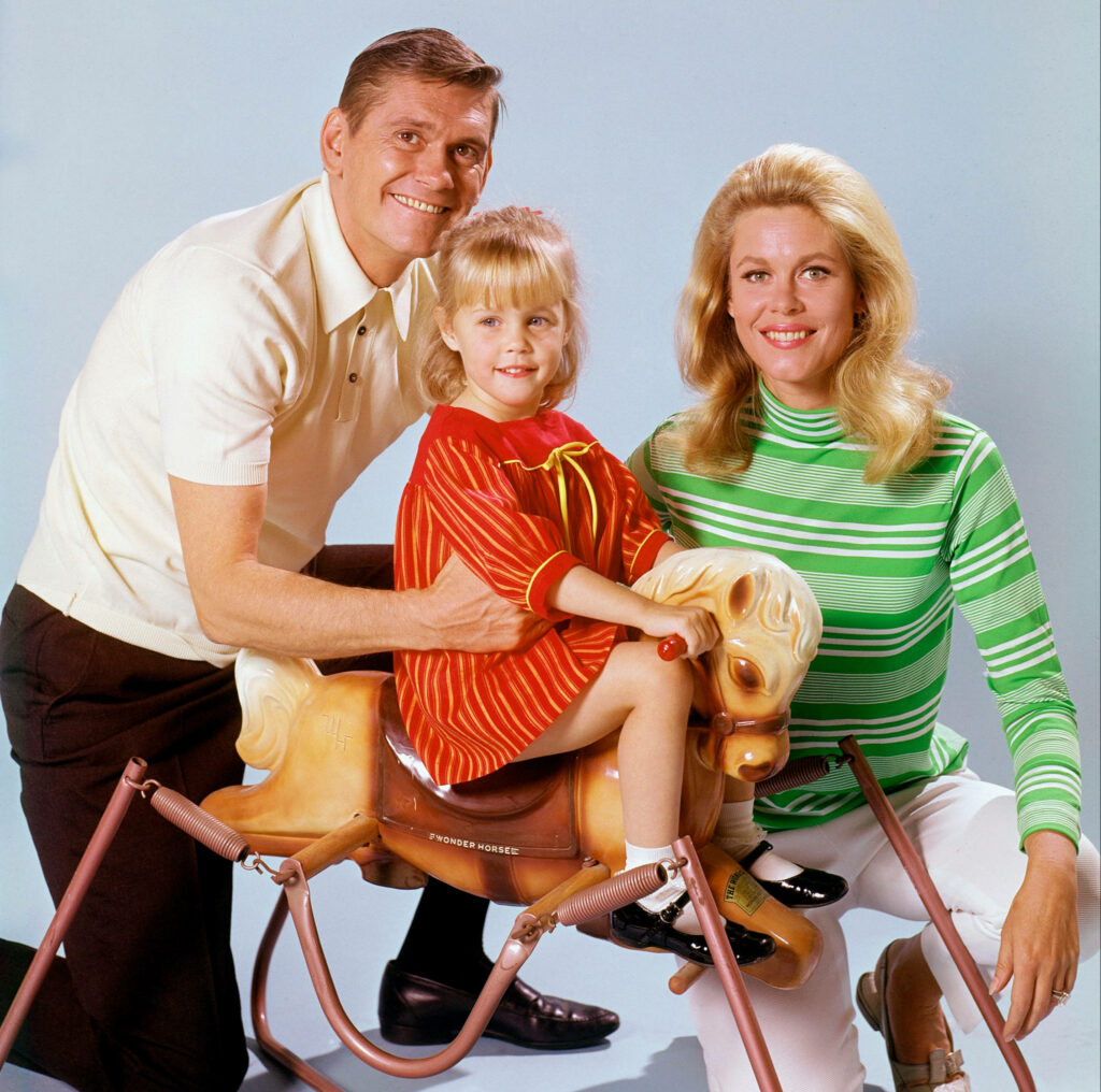 Darrin Samantha and Tabitha from Bewitched family portrait with Tabitha on vintage rocking horse Wallpaper