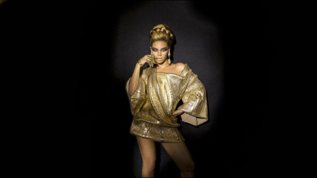 Elegant Beyonce Wallpaper: Glamorous Gold Attire on Dark Background