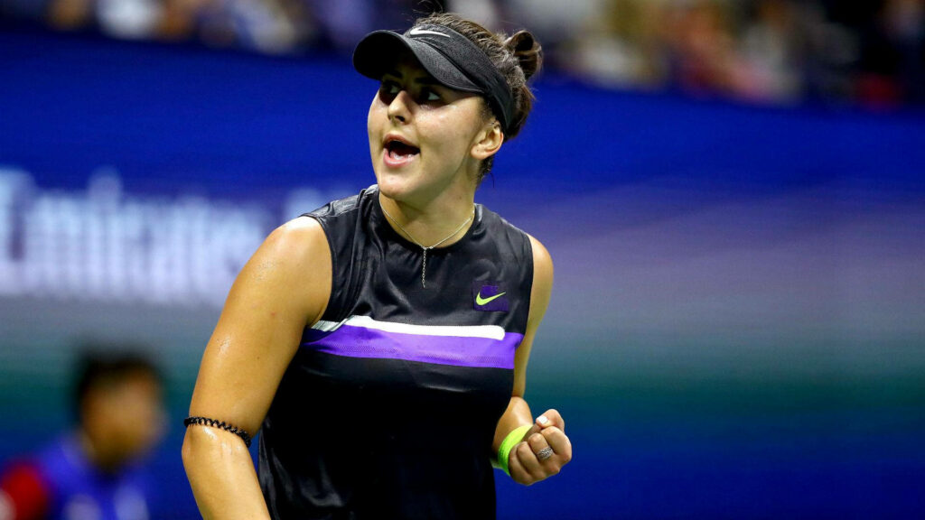 Bianca Andreescu focused and determined clenching fist on tennis court during intense match Wallpaper