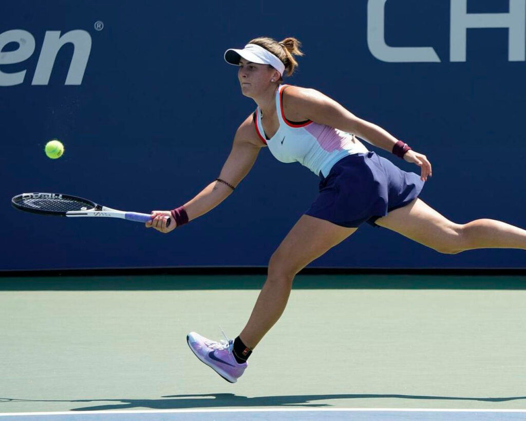 Bianca Andreescu sprinting on tennis court reaching fast-moving ball dynamic action wallpaper