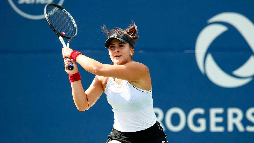 Bianca Andreescu tennis player focused holding racket ready to return shot on blue court background Wallpaper