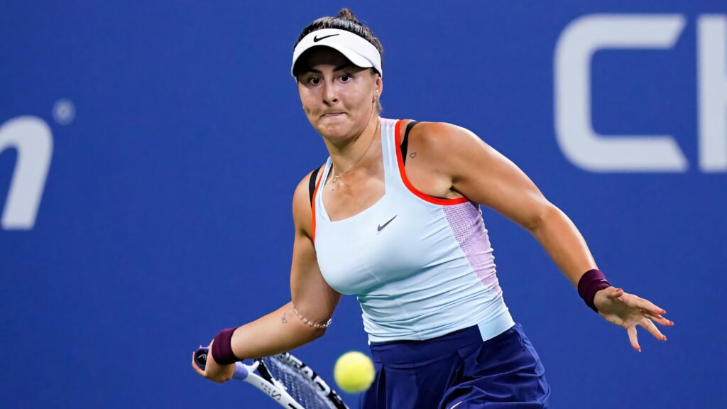 Bianca Andreescu focused powerful tennis swing athletic determination blue tournament background Wallpaper
