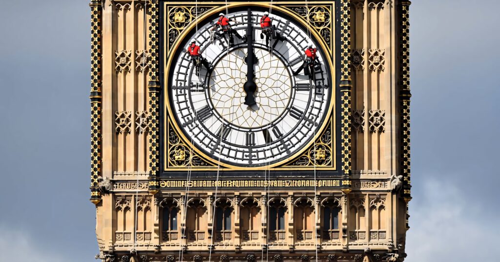 Workers suspended on ropes cleaning Big Ben clock face iconic London landmark maintenance details Wallpaper