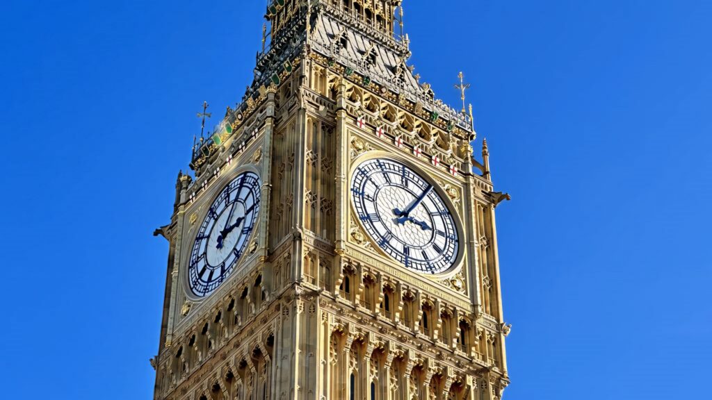 Close-up of Big Ben clock tower showing intricate architecture against vivid blue sky background Wallpaper