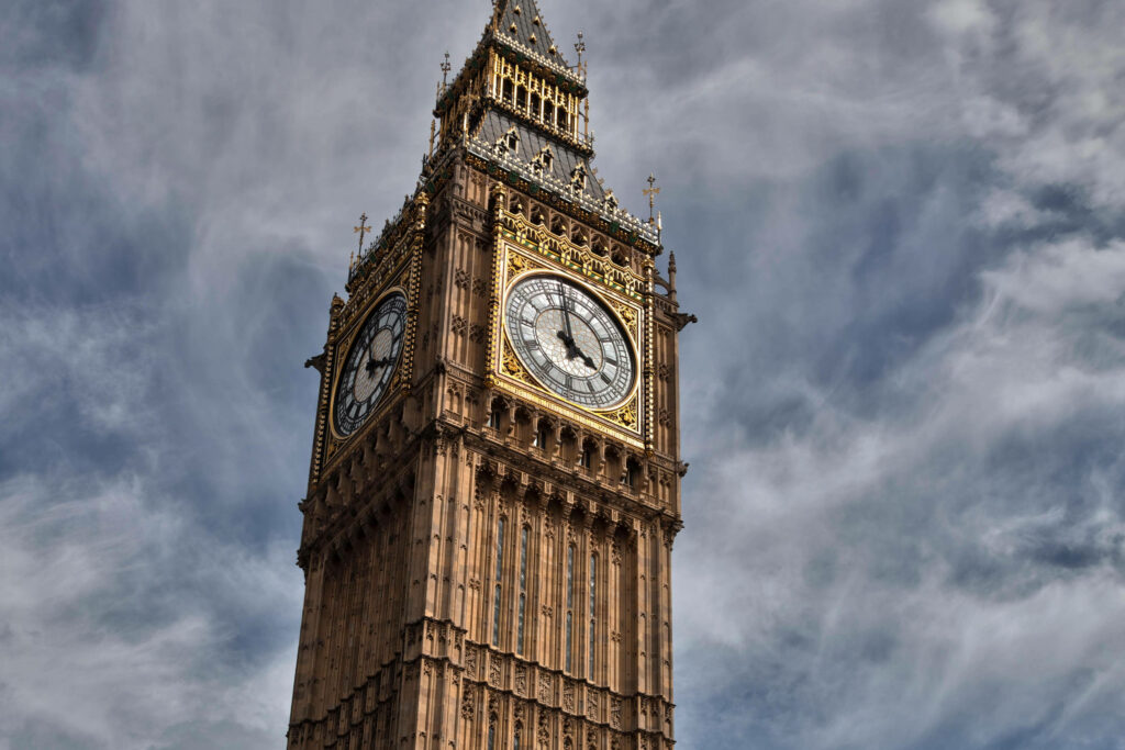 Big Ben towering under dramatic swirling storm clouds iconic London landmark wallpaper background