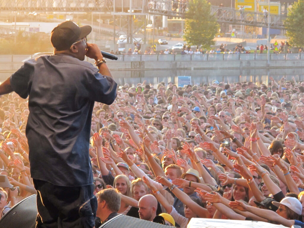 Big Boi performing live on stage with a huge energetic crowd at an electrifying outdoor concert Wallpaper