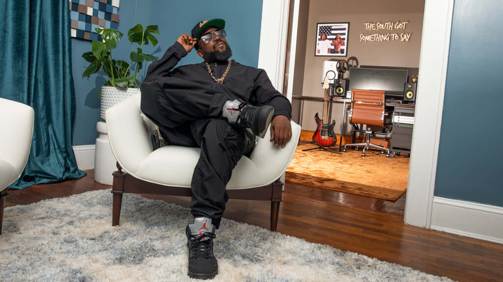 Big Boi relaxing in stylish music room with instruments and creative inspiring decor wallpaper