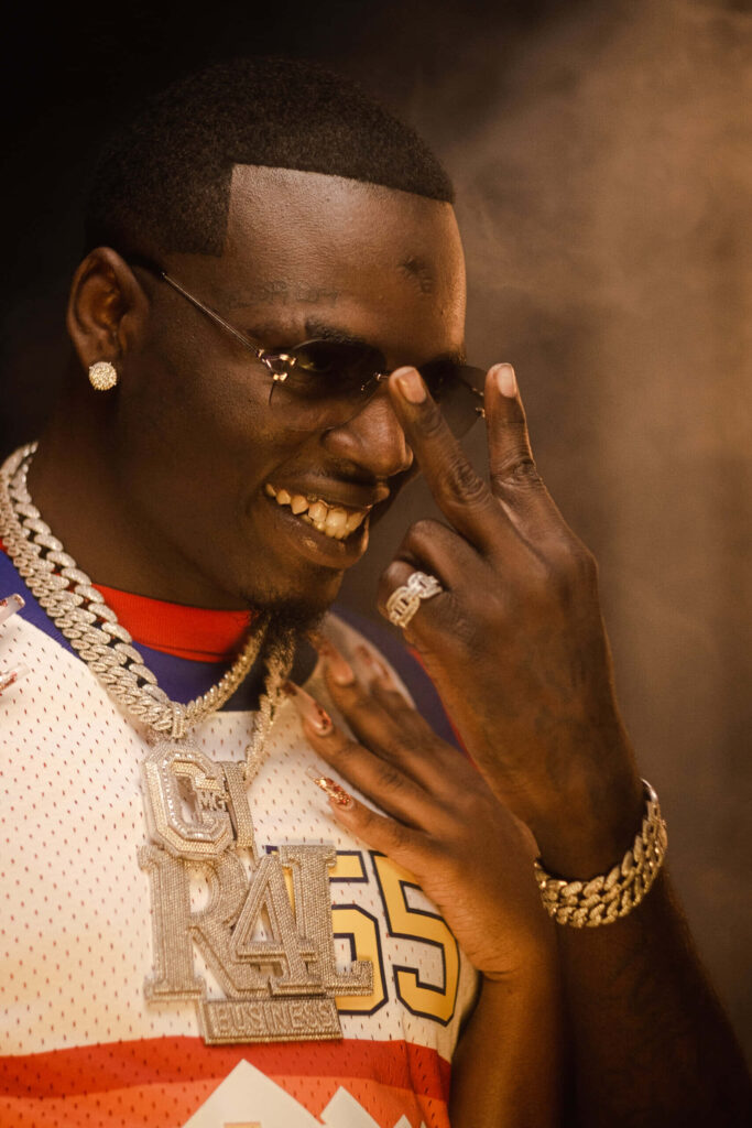 Big Boogie confident pose with stylish sunglasses and jewelry making distinct hand sign wallpaper