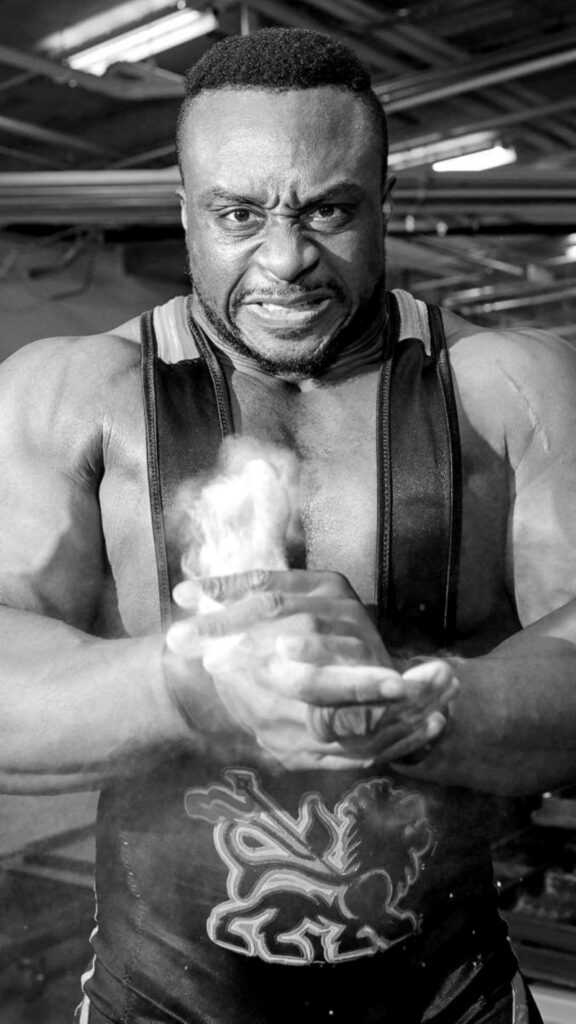 Greyscale wallpaper of wrestler Big E showing strength and intensity in dramatic pose