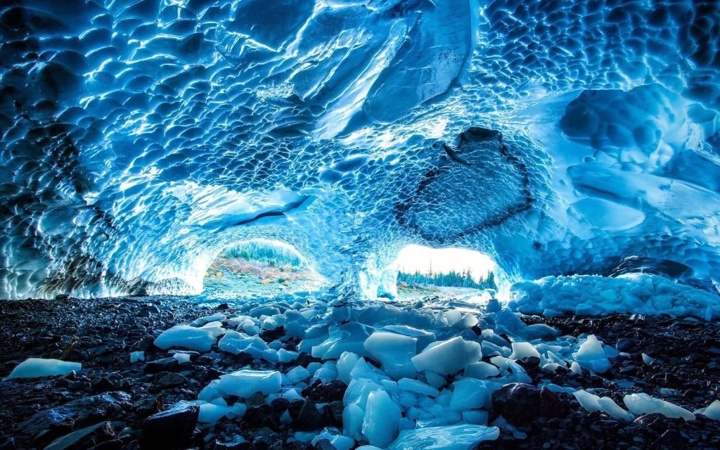 Big Four Ice Caves deep blue ice ceiling glowing sunlight rocky icy cavern floor wallpaper background