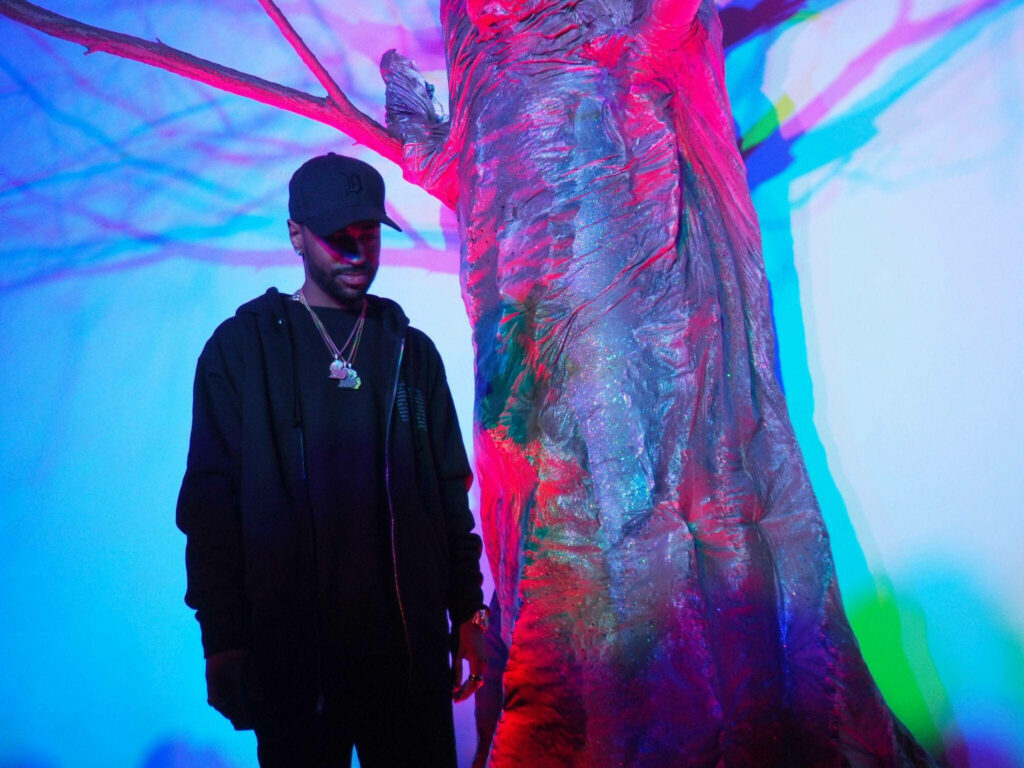 Big Sean next to neon-lit tree vibrant colorful wallpaper background atmospheric scene