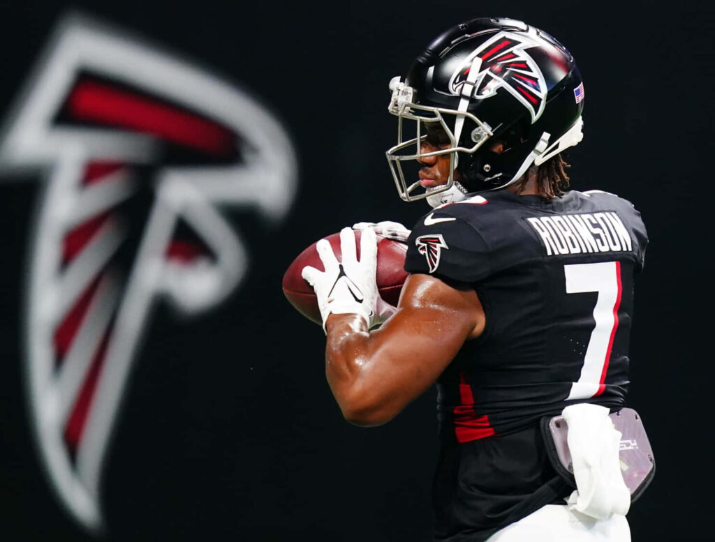 Bijan Robinson Atlanta Falcons catching football focused athletic intense dynamic wallpaper