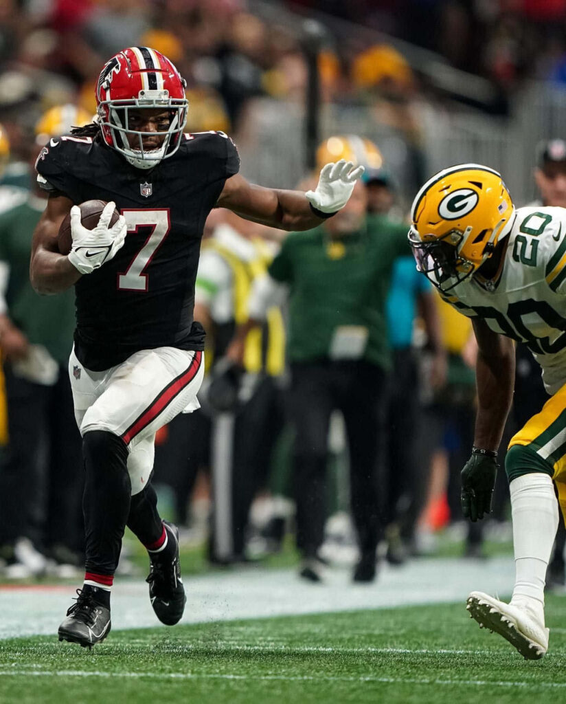 Bijan Robinson running back evades Green Bay Packers defender football action wallpaper