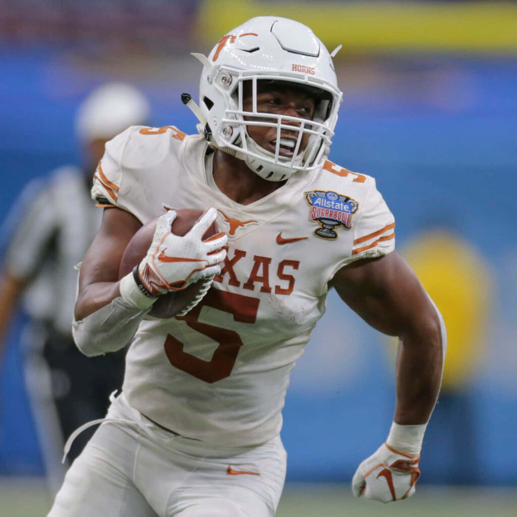 Bijan Robinson Texas Longhorns running strong in football game action wallpaper background