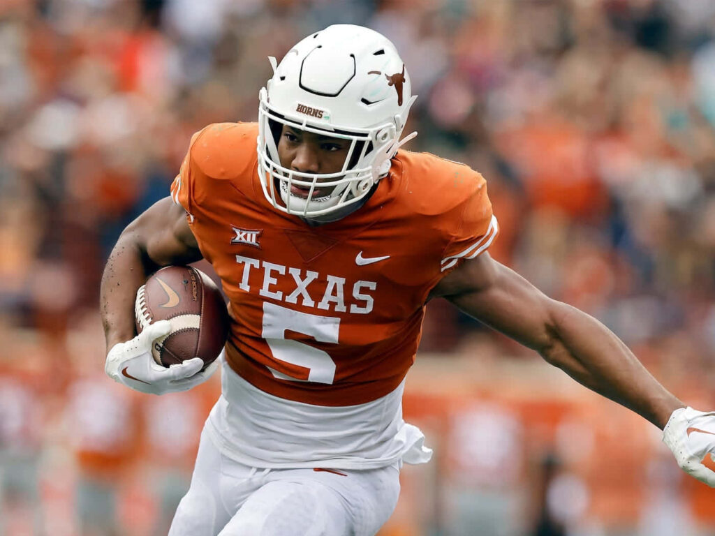 Bijan Robinson Texas Longhorns running back powerful sprint on football field action wallpaper