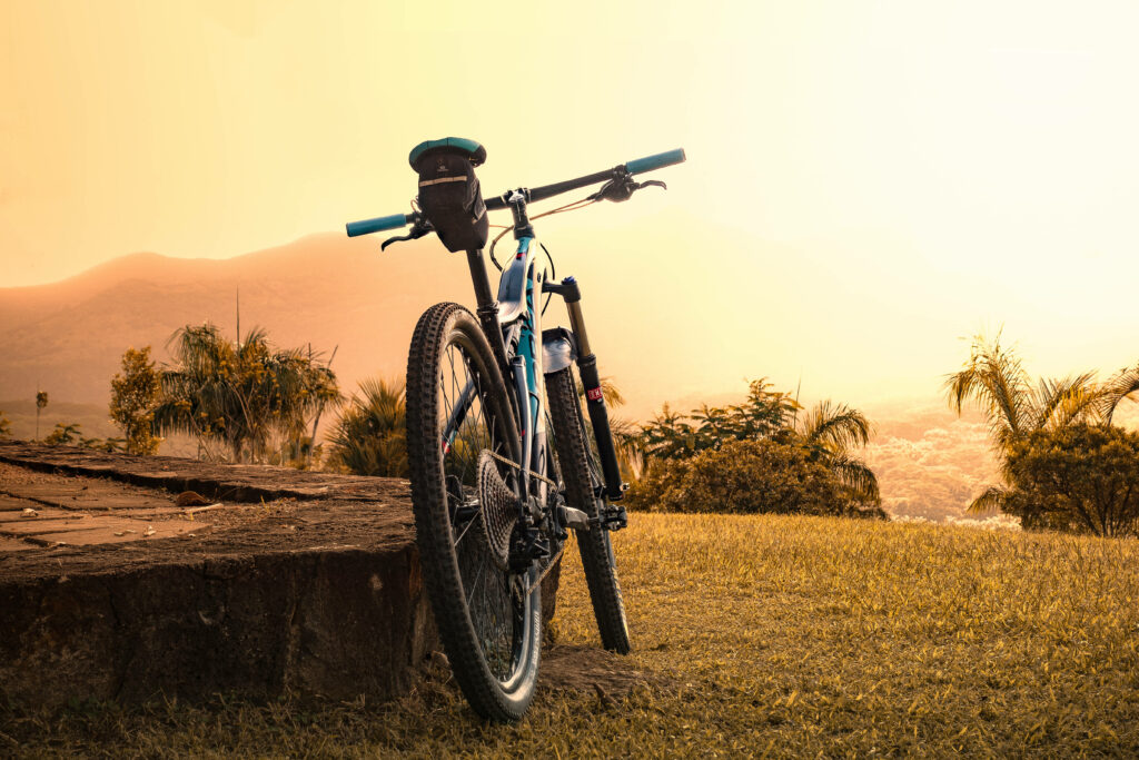 Basking in the Beauty: HD Wallpaper of a Bike Parked in Green Fields during Sunset