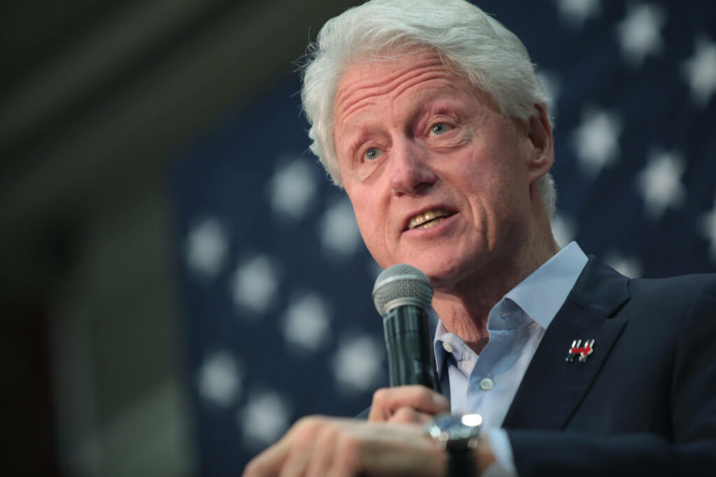 Close-up of Bill Clinton speaking with American flag backdrop patriotic wallpaper background