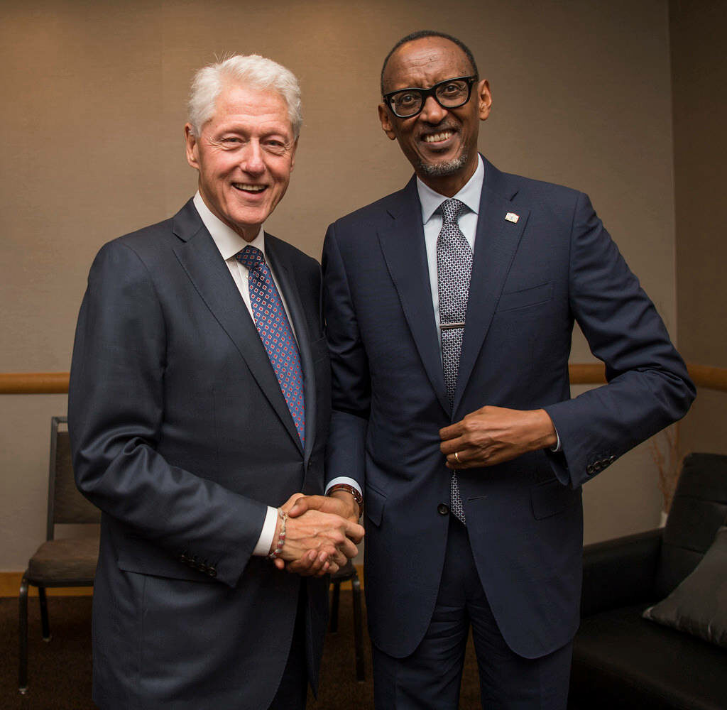 Bill Clinton and Paul Kagame in elegant suits smiling handshake symbolizing global diplomacy wallpaper