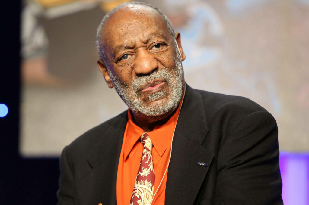 Portrait of Bill Cosby in formal suit with patterned tie thoughtful expression blurred background Wallpaper