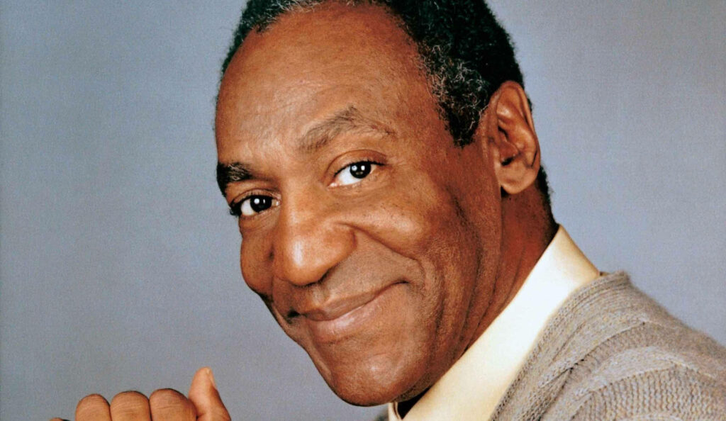 Close-up of Bill Cosby smiling warmly with a neutral background friendly expression wallpaper