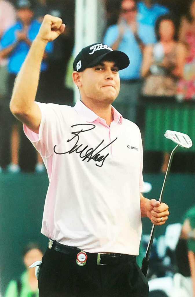 Bill Haas celebrating on golf course with prominent autograph wallpaper background