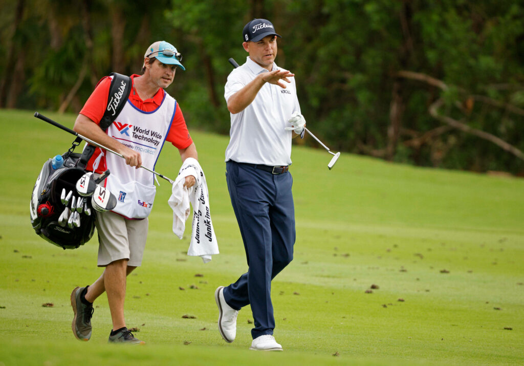 Bill Haas walking with caddie on golf course during professional golf tournament conversation Wallpaper