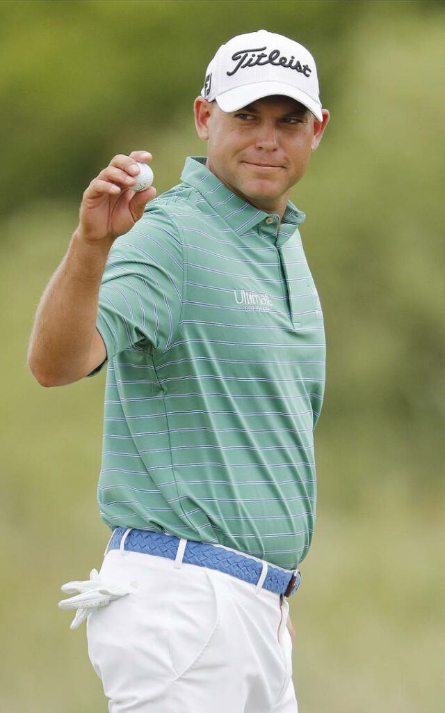 Bill Haas on golf course holding golf ball in green striped polo and Titleist cap wallpaper