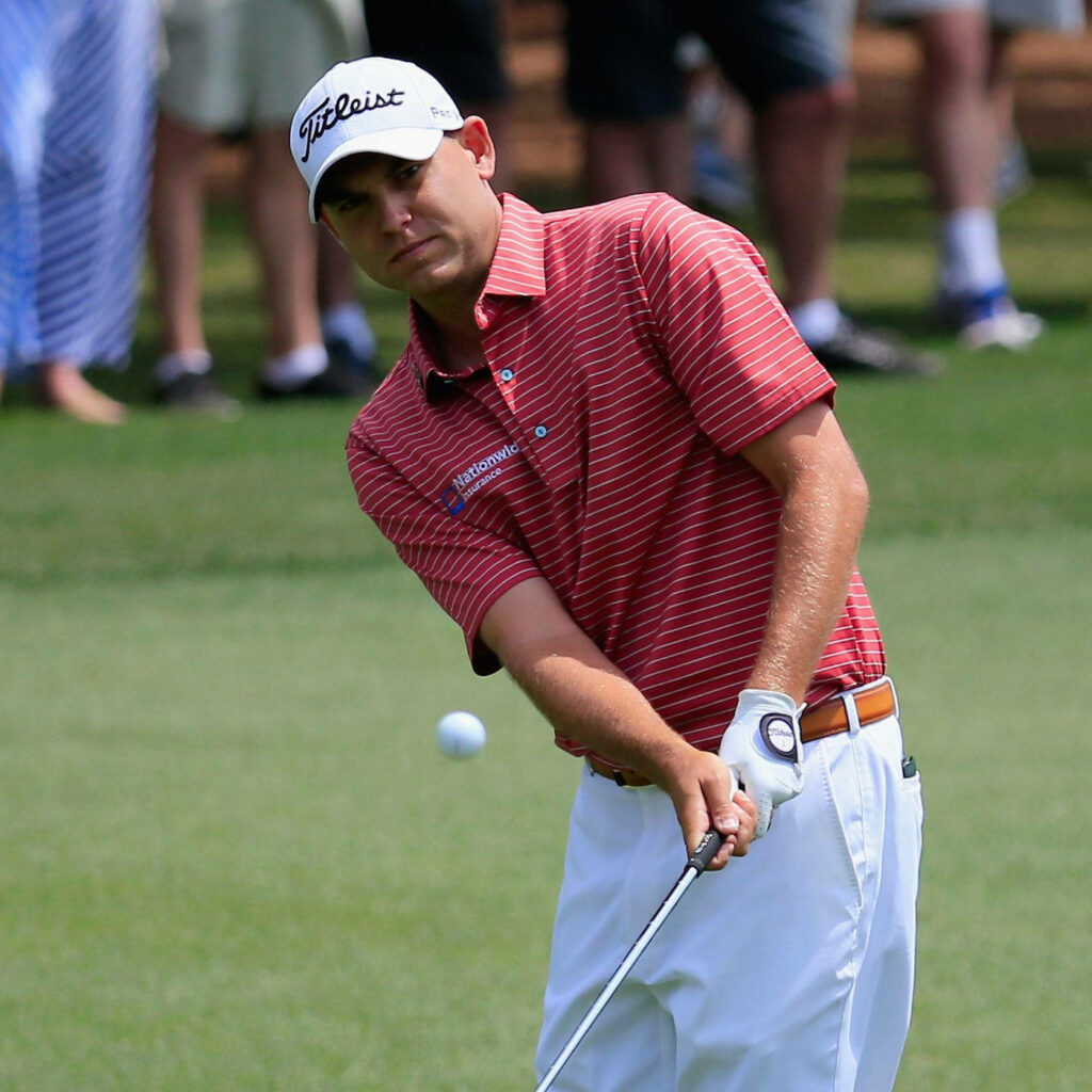 Bill Haas focused on precise golf shot with flawless technique on lush green professional course Wallpaper