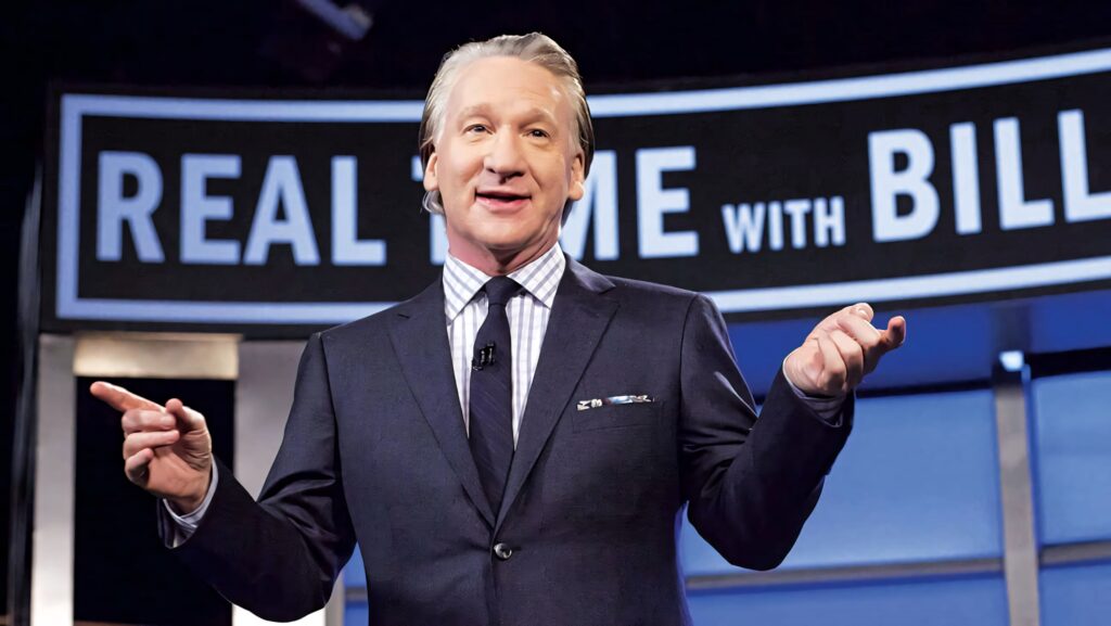 Bill Maher in a sharp suit confidently hosting Real Time with Bill Maher on set wallpaper