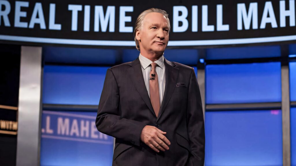 Bill Maher in sharp suit on Real Time set ready to deliver insightful political commentary wallpaper