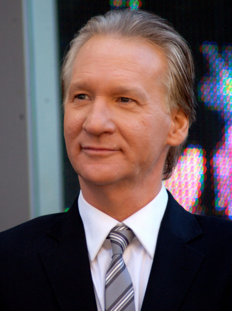 Bill Maher in sharp suit and striped tie confident professional portrait on blurred background Wallpaper