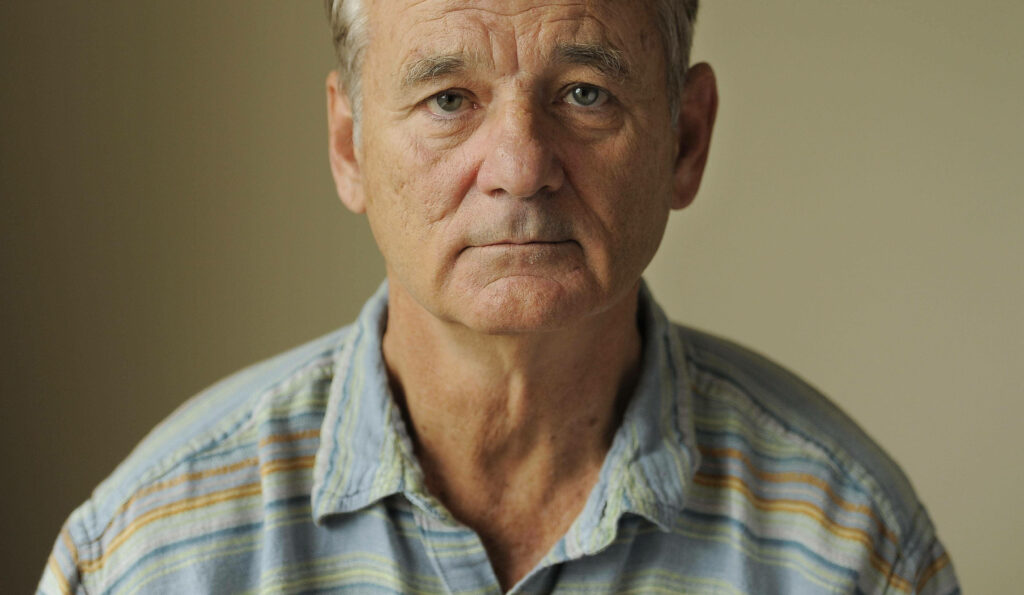 Serious portrait of Bill Murray American actor in striped shirt looking at camera neutral background Wallpaper