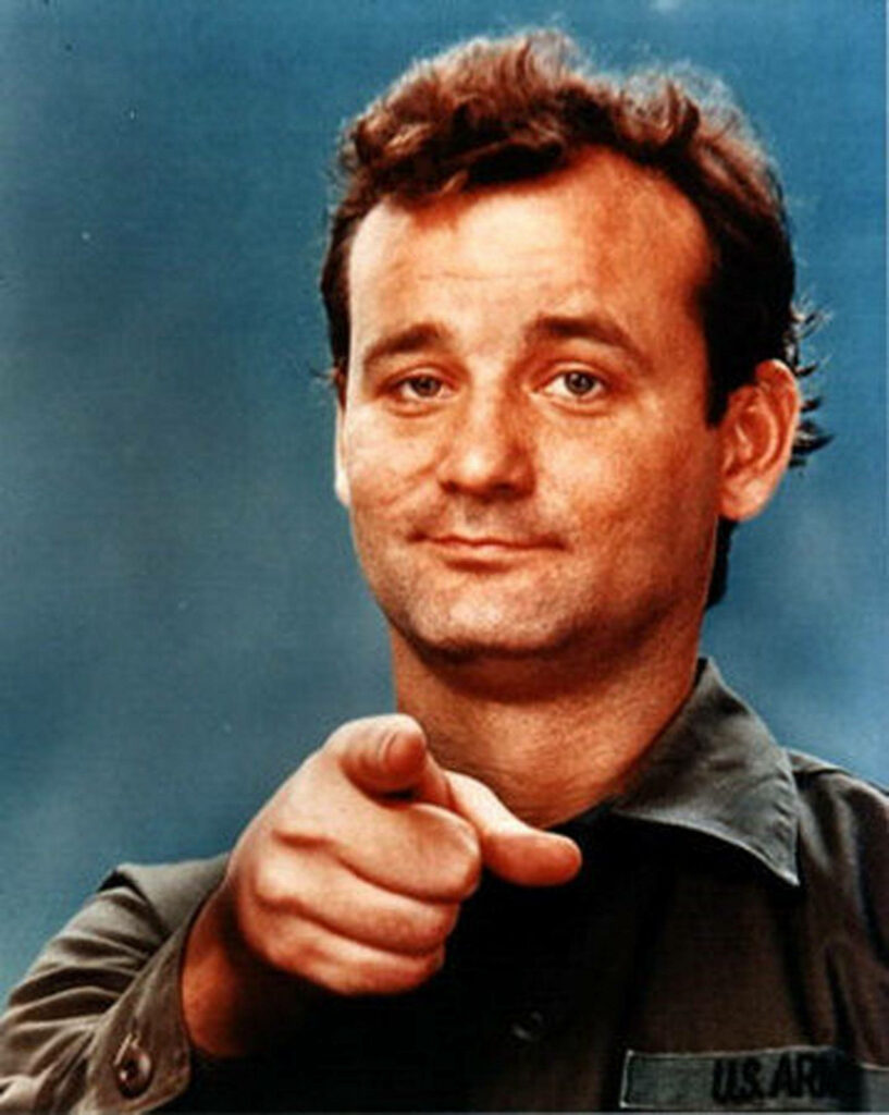 Bill Murray in US Army uniform pointing at viewer iconic Stripes movie scene blue background Wallpaper