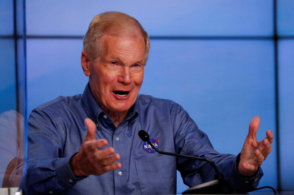 Bill Nelson speaking with expressive hands against modern blue background dynamic wallpaper