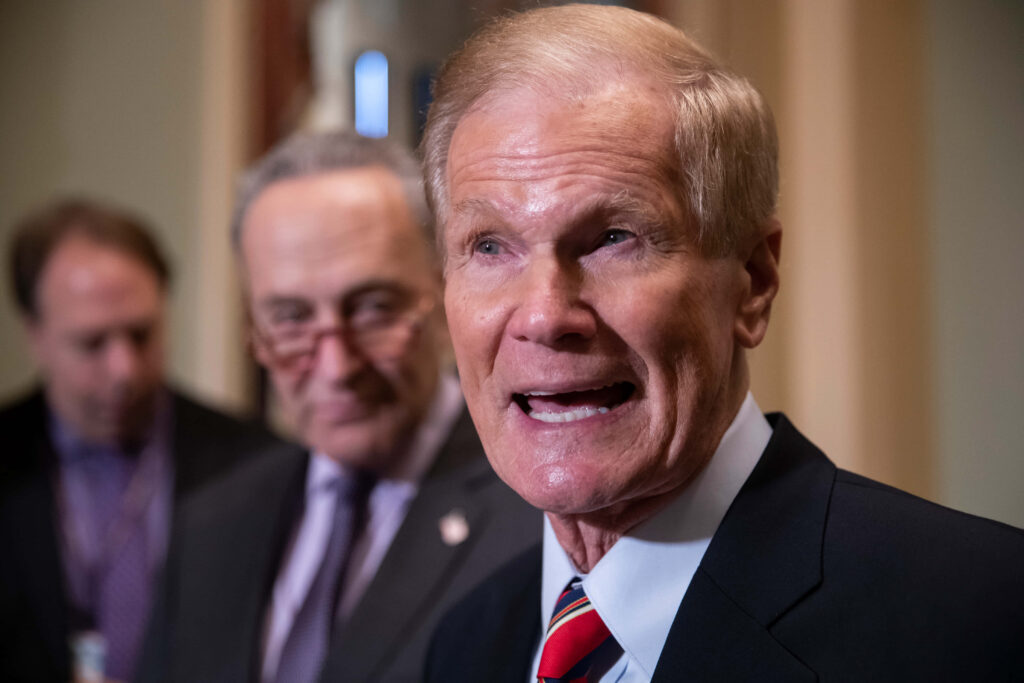 Bill Nelson speaking passionately at formal event with officials in dynamic setting wallpaper background