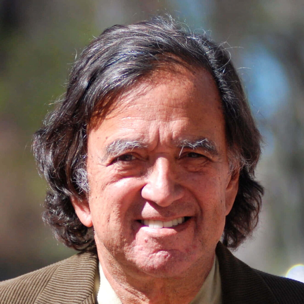 Bill Richardson close-up portrait warm smile natural expression outdoor blurred background Wallpaper