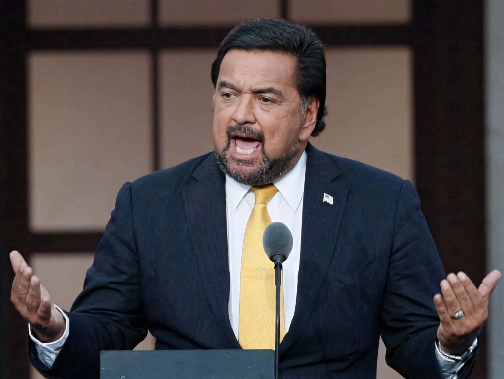 Bill Richardson delivering a powerful speech at the podium with expressive leadership gesture wallpaper